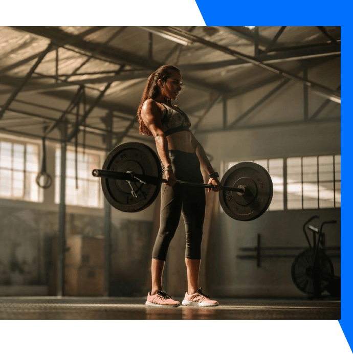 A woman is holding onto two large barbells